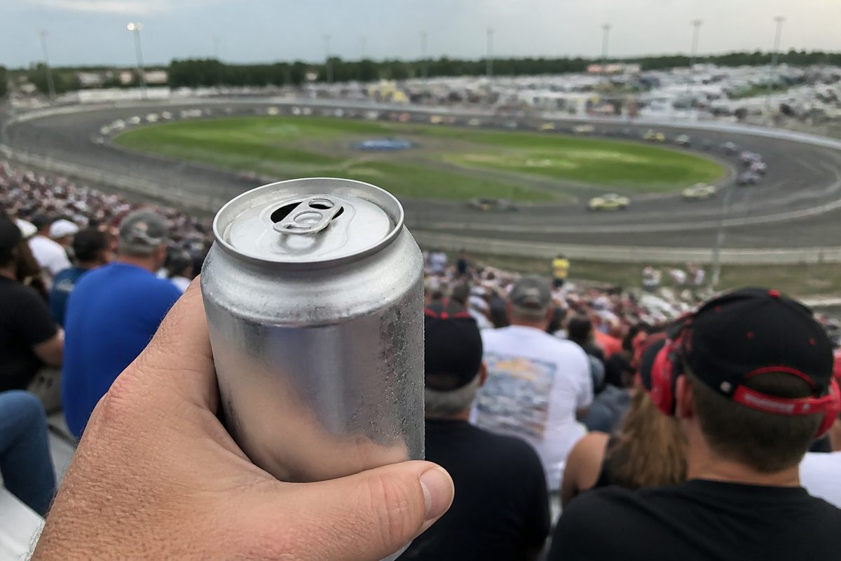 Opened cold lager can overlooking the racetrack