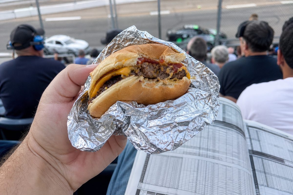 Partially eaten cheeseburger in foil at the race