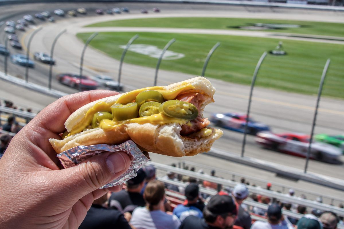 POV of a jalapeno mustard hot dog over the racetrack